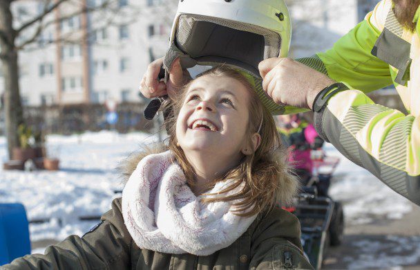 Kiddi-Car Kinderverkehrstraining Kiddi-Car: das Winter-Event nahe München - sicher mit 2G+ 5 Glückliches Mädchen auf Quad mit Helm im Winter